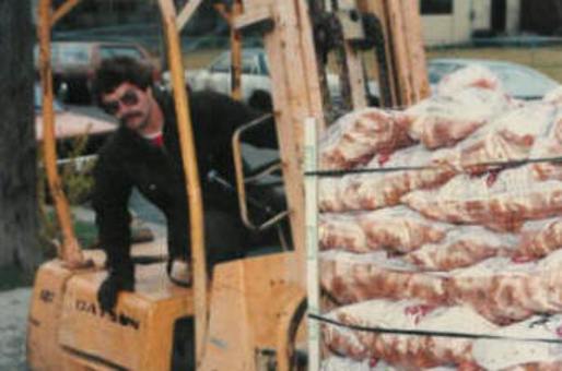 Jim Robertson transfers totes of 10 pound bags of potatoes from the semi truckload to the sidewalk on the side of the church for the Easter Holiday GiveAway.